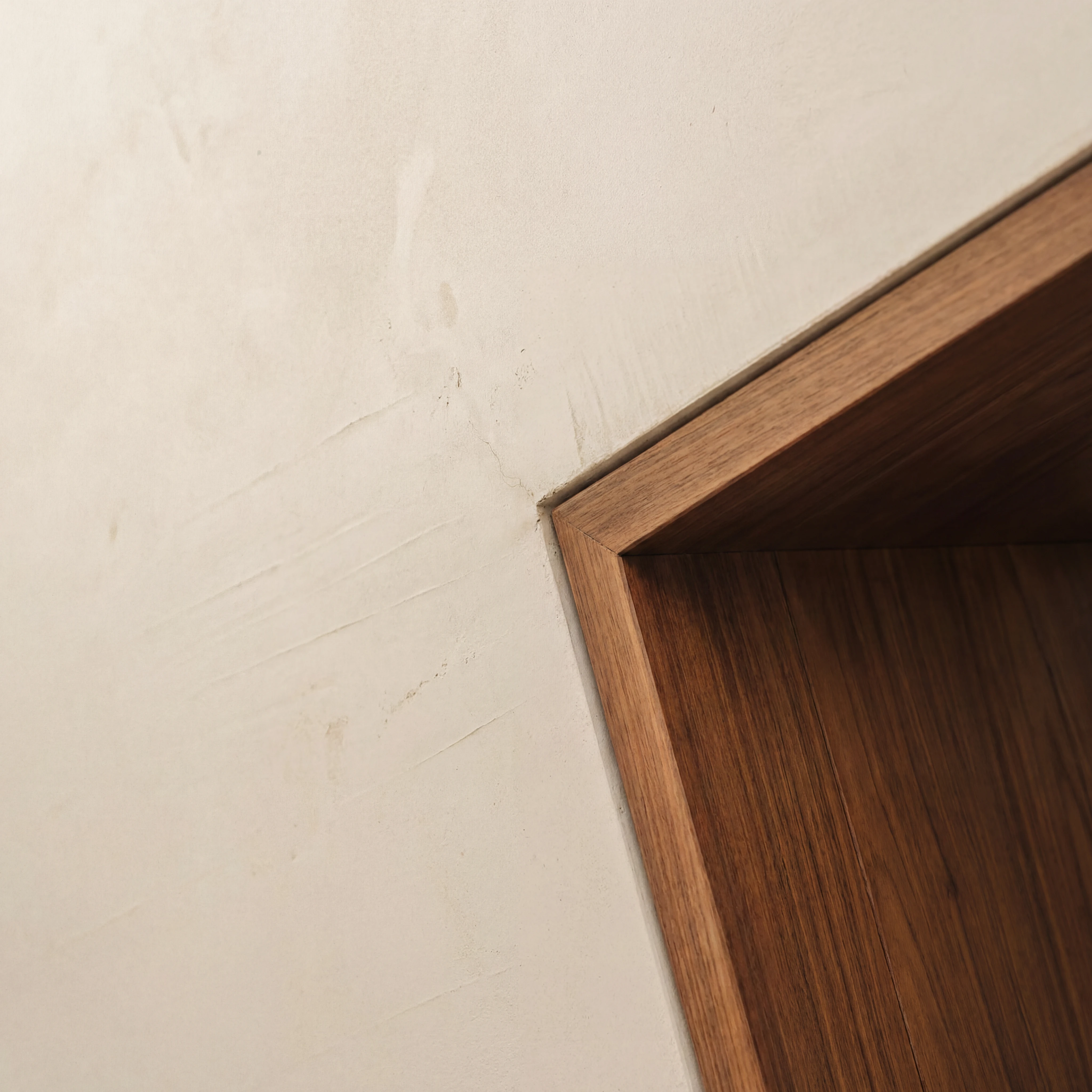 Casa entre cales — detalle del nicho de chestnut empotrado en muro encalado.